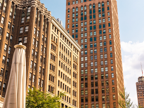 The Stott, a brown high-rise building with another, lighter brown high-rise building partially obscuring it.